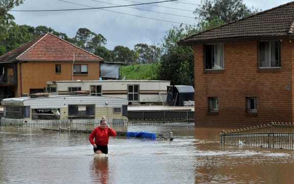 A resident fades through water in western Sydney on March 3, 2022, as the area faces its worst flooding after record rainfall caused its largest dam to overflow.