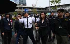 Police watch as a group of residents hold the first authorised protest and march in several years in Hong Kong against the proposal for reclamation in the district on Tseung Kwan O on 26 March, 2023.