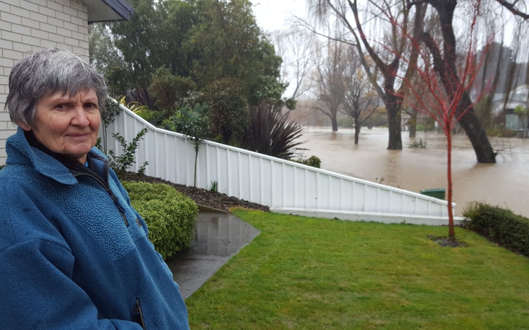 A worried Christine Bridgman returns after a night a way to check on her Riverlaw terrace home in Christchurch, but the street outside her house is fully flooded.