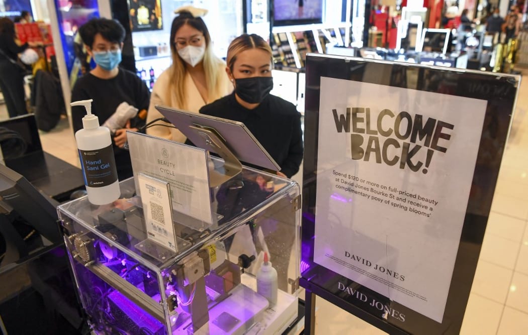 People shop in a department store in Melbourne on October 29, 2021 as the city further lifts Covid restrictions allowing non-essential retail shops to open and travel to the regions of Victoria after the city's sixth lockdown.