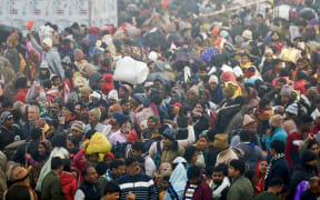 Hindu pilgrims arrive to take a dip in Sangam, the confluence of Ganges, Yamuna and mythical Saraswati rivers, during the Maha Kumbh Mela festival, on a cold winter morning in Prayagraj on January 13, 2025. Vast crowds of Hindu pilgrims in India began bathing in sacred waters on January 13, as the Kumbh Mela festival opened, with organisers expecting 400 million people -- the largest gathering of humanity.