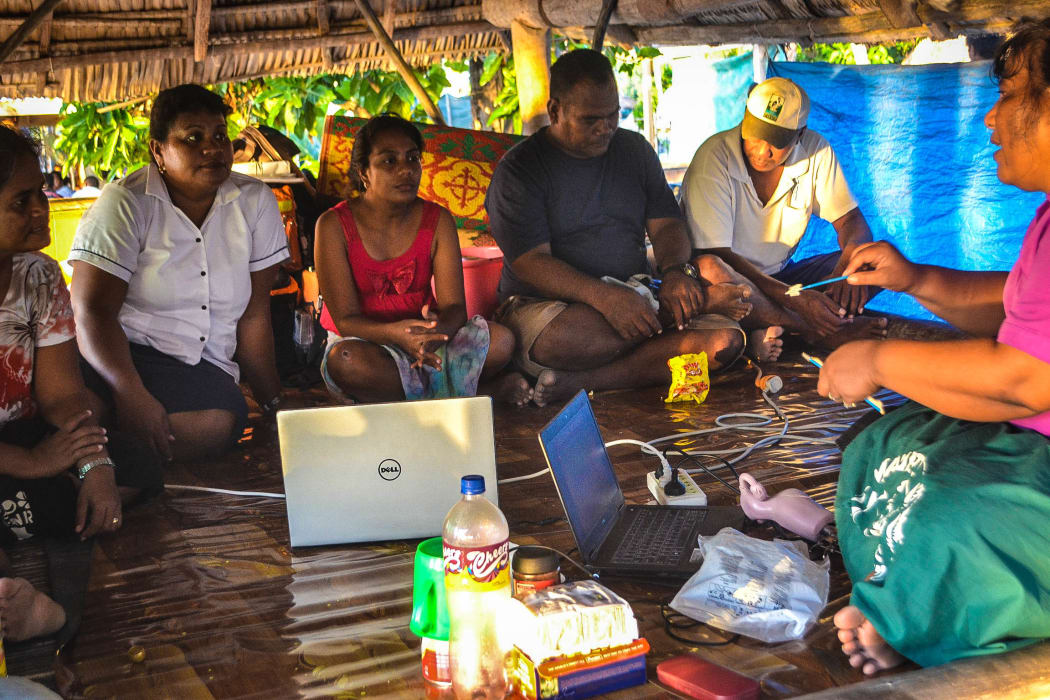 Lab technologists in Kiribati training nurses on an outer island to perform pap smear tests.