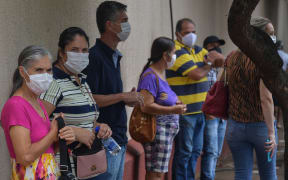 Residents line up to receive the Coronavac vaccine against Covid-19, in Serrana, Brazil, on February 17, 2021.