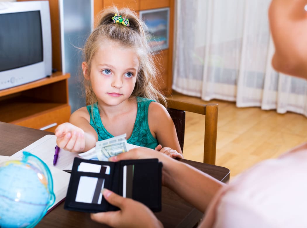 A Portrait of little schoolgirl asking money for a day