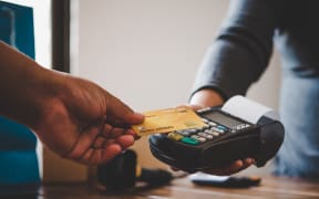 Close up of hand using credit card to pay.