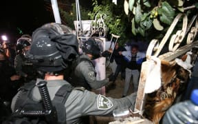 Israeli forces force a door of a Palestinian family to raid the house as Palestinians gather to stage a demonstration at Sheikh Jarrah neighborhood after Israeli government's plan to force some Palestinian families out of their homes in East Jerusalem on May 06, 2021.