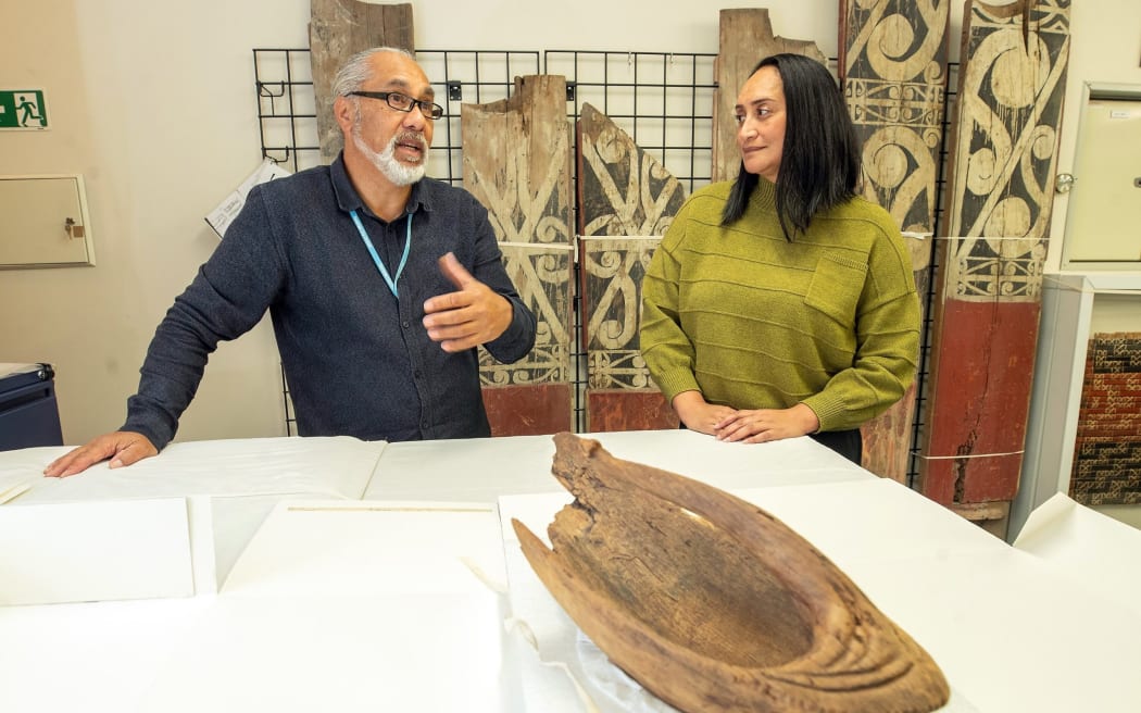 Cultural heritage manager Dean Flavell and museum collection specialist Chelsea Tairi with a 14th century wooden canoe bailer.
