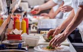 Cooks in a restaurant kitchen.