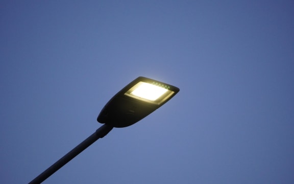 Lighting mast with lantern on a city street during the day. Lighting of roads and streets, stadiums against the blue sky.