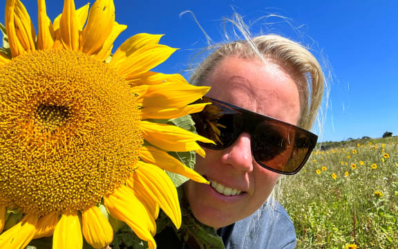 Rachel Short poses with one of her sunflowers.