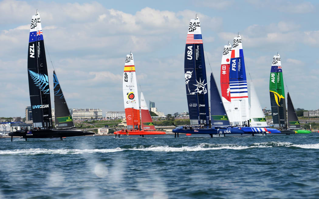 New Zealand SailGP Team, Spain SailGP Team, USA SailGP Team, Japan SailGP Team, France SailGP Team and Australia SailGP Team foiling across Plymouth Sound on race day 1 at Great Britain SailGP, Event 3, Season 2 in Plymouth, UK. 17 July 2021.