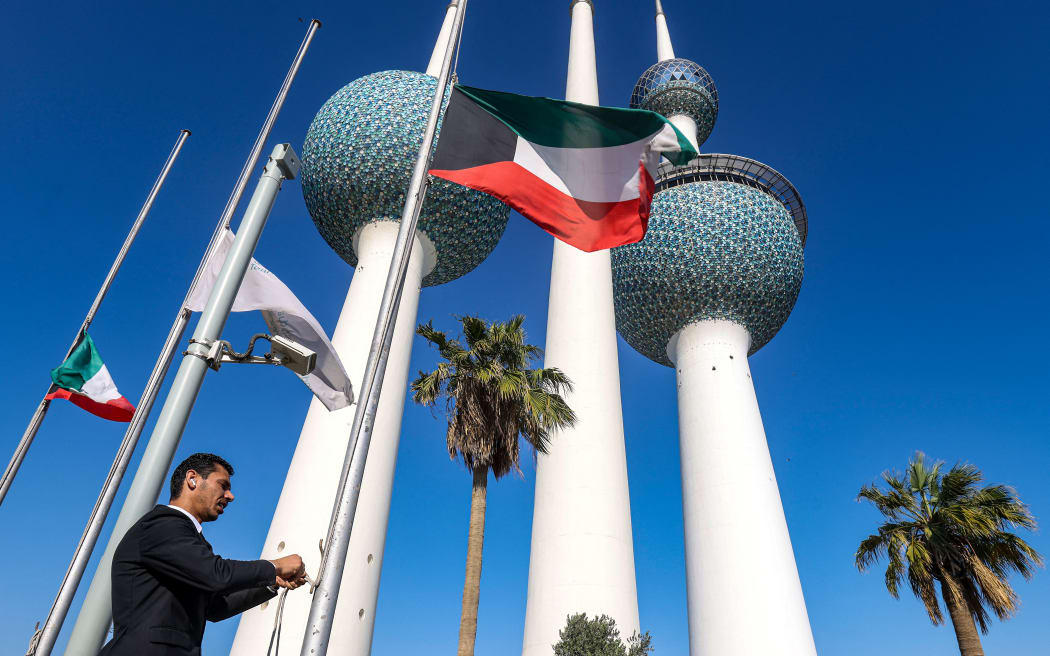 Kuwait's national flags are lowered to half-mast outside the Kuwait Towers in Kuwait City on 16 December, 2023, as the Gulf country mourns the death of its leader the late emir Sheikh Nawaf al-Ahmad Al-Sabah.