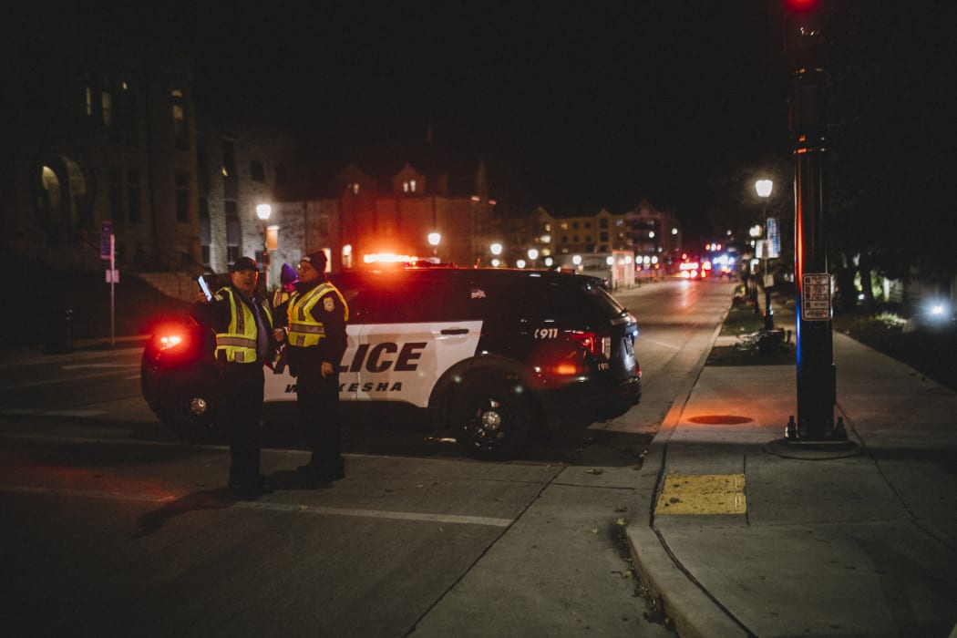 Police and emergency personnel work on a crime scene on 21 November 2021 in Waukesha, Wisconsin.