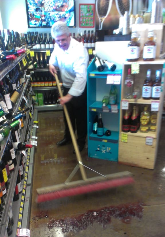 David, a retail worker, mops up a bottle store in Sumner.