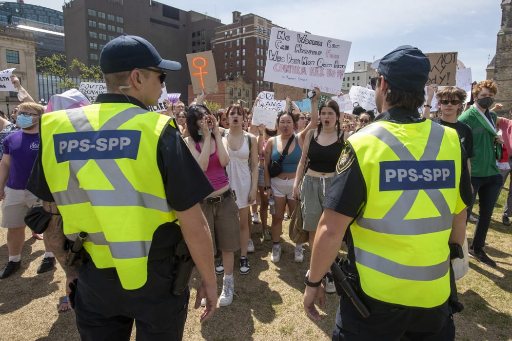 Parliamentary Protective Service officers keep pro-choice protesters separate from the pro-life protesters during the National March for Lifein Ottawa, Ontario, on May 12, 2022. - The protest comes amid a political firestorm in the United States ignited by a leaked draft opinion that showed the Supreme Court's conservative majority preparing to overturn Roe v. Wade, a landmark 1973 ruling guaranteeing abortion access nationwide. (Photo by Lars Hagberg / AFP)