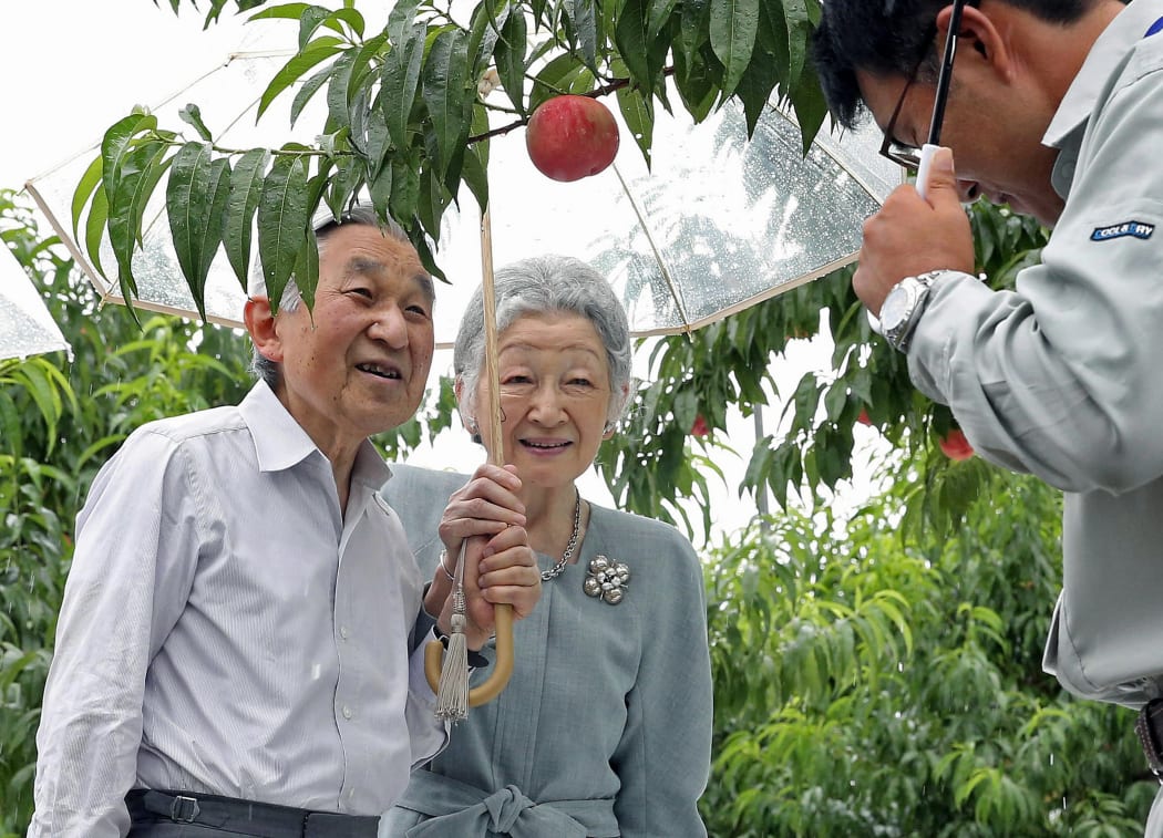 Emperor Akihito and Empress Michiko visit a peach farmer in Fukushima.