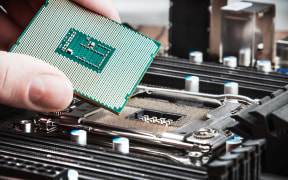 CPU in hand before installation into the motherboard
