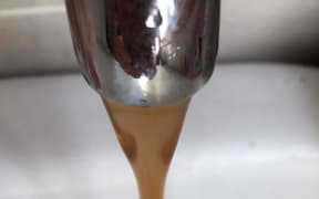 Discoloured water flows from a tap in Kaeo.