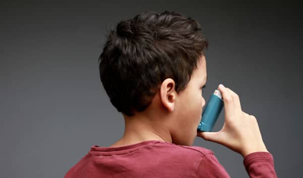 child with flu and inhaler respiratory puff on grey background with people stock image stock photo