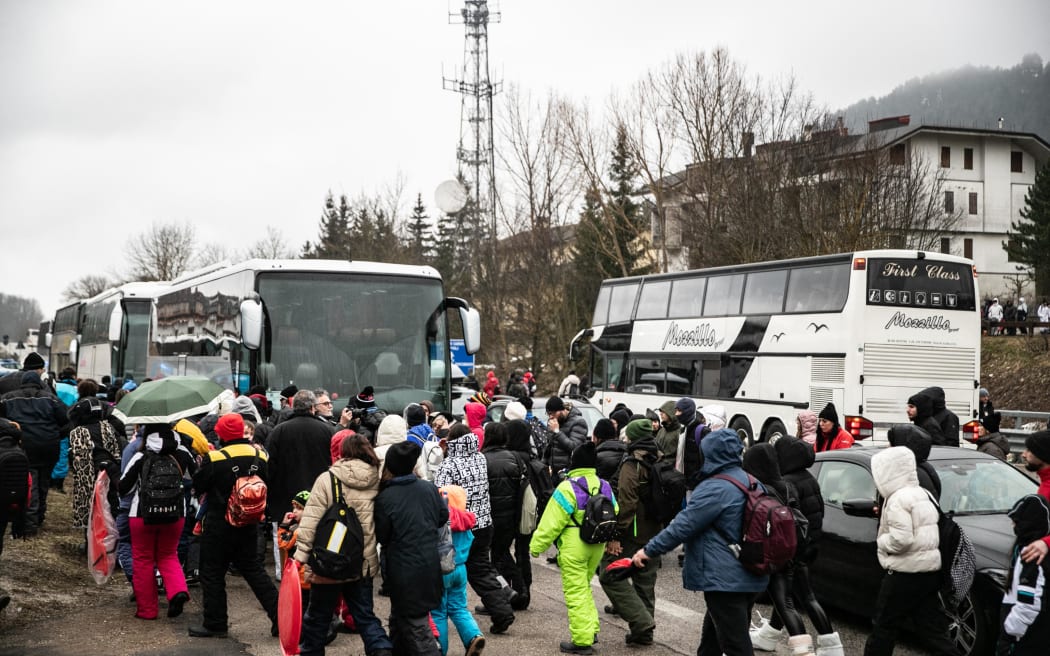 People board buses after a day in the small ski resort of Roccaraso, on February 2, 2025. Local authorities limited the numbers after more than 200 buses with approximately 10,000 tourists turned up last weekend after a call by Neopolitan tiktok star Rita De Crescenzo to join her in the small town in the central Abruzzo region, causing huge traffic jams and chaos.