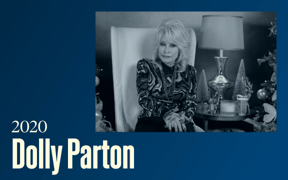 A older woman sits is a well appointed living room, text reads "2020, Dolly Parton"