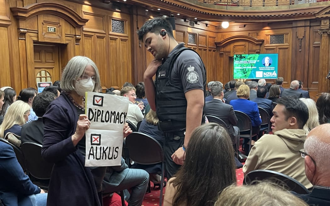 Eight security officers from Parliament carried out a member of the public protesting against AUKUS at the Legislative Council Chamber after she refused to leave on 1 May, 2024. Minister of Foreign Affairs and Trade Winston Peters was giving a speech, providing an update on Pillar Two talks.