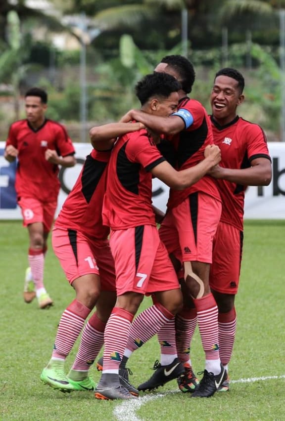 Tuia Falepapalangi is embraced by his teammates after scoring the equalising goal for Tonga.