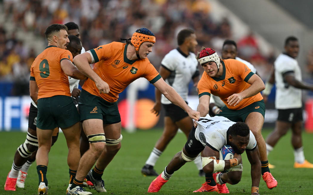 Fiji's flanker Lekima Tagitagivalu (C) is tackled by Australia's flanker Tom Hooper (L) and Australia's flanker Fraser McReight (R) during the France 2023 Rugby World Cup Pool C match between Australia and Fiji at Stade Geoffroy-Guichard in Saint-Etienne, south-eastern France on September 17, 2023. (Photo by Olivier CHASSIGNOLE / AFP)
