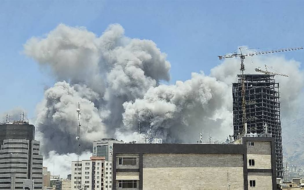 This UGC image posted on social media on June 23, 2025 shows a plume of smoke billowing after Israeli strikes in Tehran the same day. Israel said it struck Iran Revolutionary Guards sites in Tehran and the city's notorious Evin prison on June 23, instensifying its attacks a day after the United States hit the Islamic republic's nuclear facilities (Photo by UGC / AFP) / RESTRICTED TO EDITORIAL USE - MANDATORY CREDIT "AFP PHOTO / UGC / ANONYMOUS  " - NO MARKETING NO ADVERTISING CAMPAIGNS  -NO ACCESS ISRAEL MEDIA/PERSIAN LANGUAGE TV STATIONS OUTSIDE IRAN/ STRICTLY NO ACCESS BBC PERSIAN/ VOA PERSIAN/ MANOTO-1 TV/ IRAN INTERNATIONAL/RADIO FARDA  - AFP IS NOT RESPONSIBLE FOR ANY DIGITAL ALTERATIONS TO THE PICTURE'S EDITORIAL CONTENT /
