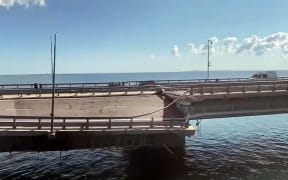 This video grab taken from a ?rimea24TV footage on July 17, 2023 shows the damaged Kerch bridge -- linking Crimea to Russia -- which was heavily damaged following an attack. Russia on July 17, 2023, said a Ukrainian attack on the bridge linking Moscow-annexed Crimea to the Russian mainland killed a civilian couple and wounded their child. Moscow said two drones had hit the bridge in the early hours and blamed "the Kyiv regime." (Photo by Crimea24TV / AFP)
