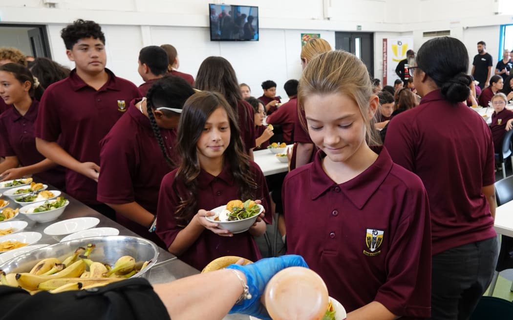 Year 7 and 8 students at Tikipunga High School line up for a squirt of sweet chili sauce on their nachos. Photo: RNZ / Peter de Graaf