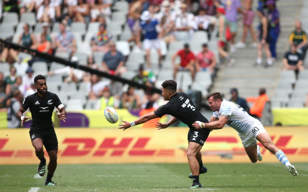 Tone Ng Shiu of New Zealand gets his pass away to Akuila Rokolisoa against Argentina at the Cape Town Sevens.