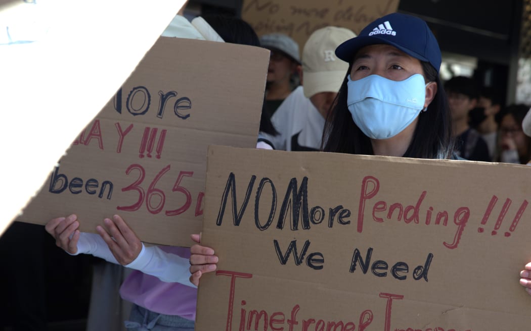 Hundreds of Chinese took to Auckland's Queen St on Sunday (12 November, 2023) to protest against National Security Check delays their Resident Visa applications.