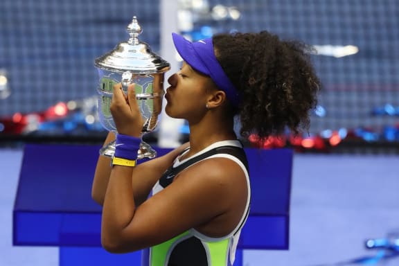 NEW YORK, NEW YORK - SEPTEMBER 12: Naomi Osaka of Japan kisses the trophy in celebration after winning her Women's Singles final match against Victoria Azarenka of Belarus