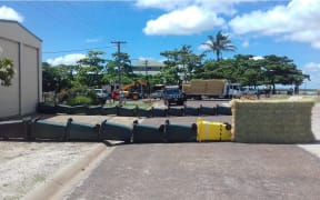 A group of Queensland residents have tried to lead a stray 3.8m crocodile back to the water's edge using a wall of wheelie bins.