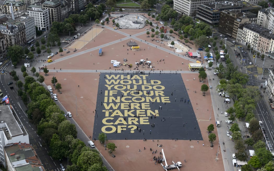 Plainpalais place in Geneva shows a giant poster reading "What would you do if your income was taken care of?".
