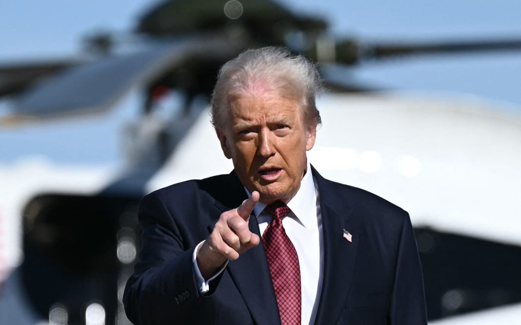 US President Donald Trump gestures as he walks to board Air Force One at Joint Base Andrews, Maryland on November 5, 2025. Trump is traveling to Miami to speak at the America Business Forum. (Photo by Brendan SMIALOWSKI / AFP)