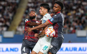 New Zealand's Marko Stamenic surrounded by New Caledonia defenders.