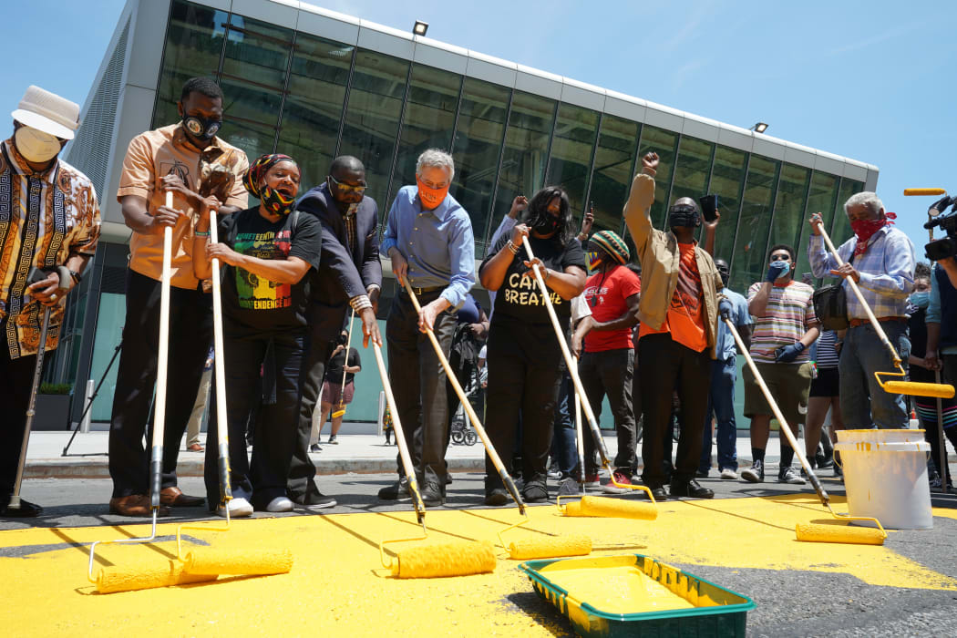 New York City Mayor Bill de Blasio (5th L) helps volunteers paint New York Citys second Black Lives Matter mural in the Borough of Staten Island on 19 June, 2020, as the city marks Juneteenth.