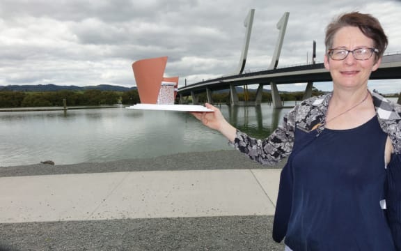 Photographer Diane Stoppard with the model of the camera obscura sculpture, in front of Whangarei's bascule bridge.