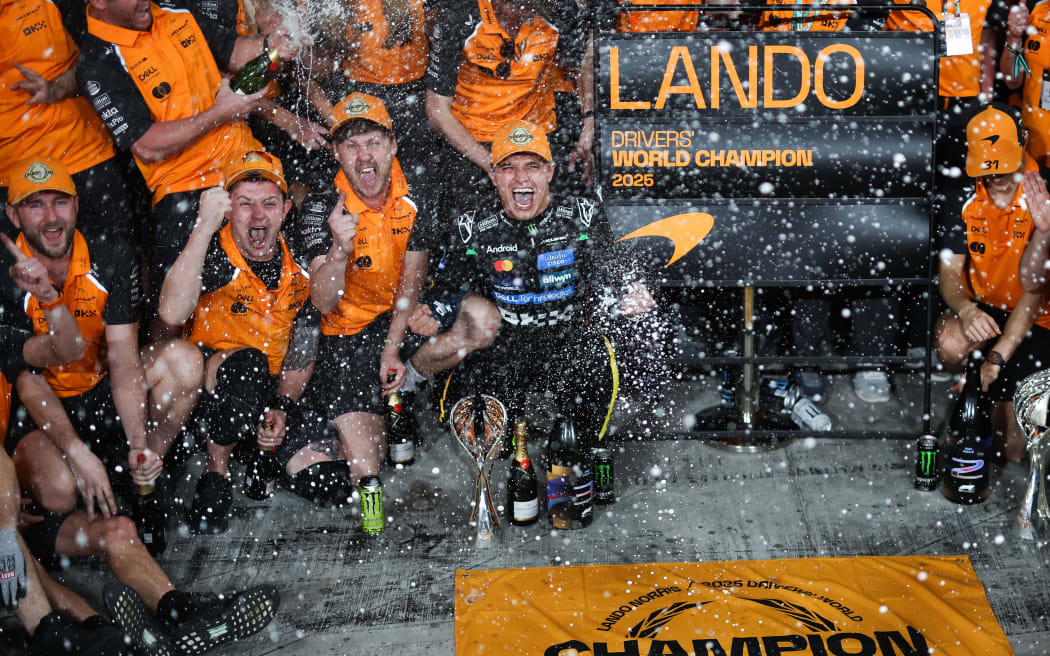 Lando Norris celebrates his F1 world championship with McLaren team, Abu Dhabi, 2025.