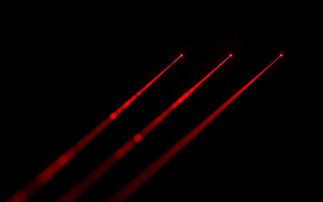 Red laser beams on black background