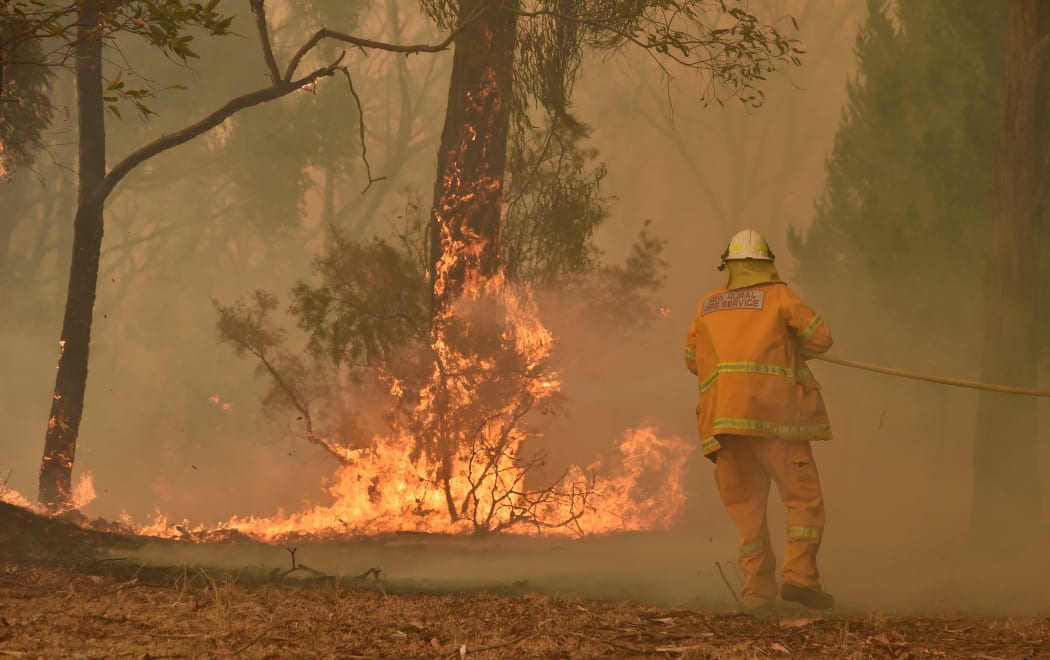 A fireman fights a bushfire to protect a property in Balmoral, 150 kilometres southwest of Sydney on December 19, 2019.