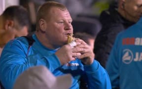 Sutton reserve goalkeeper Wayne Shaw tucks into a pie.