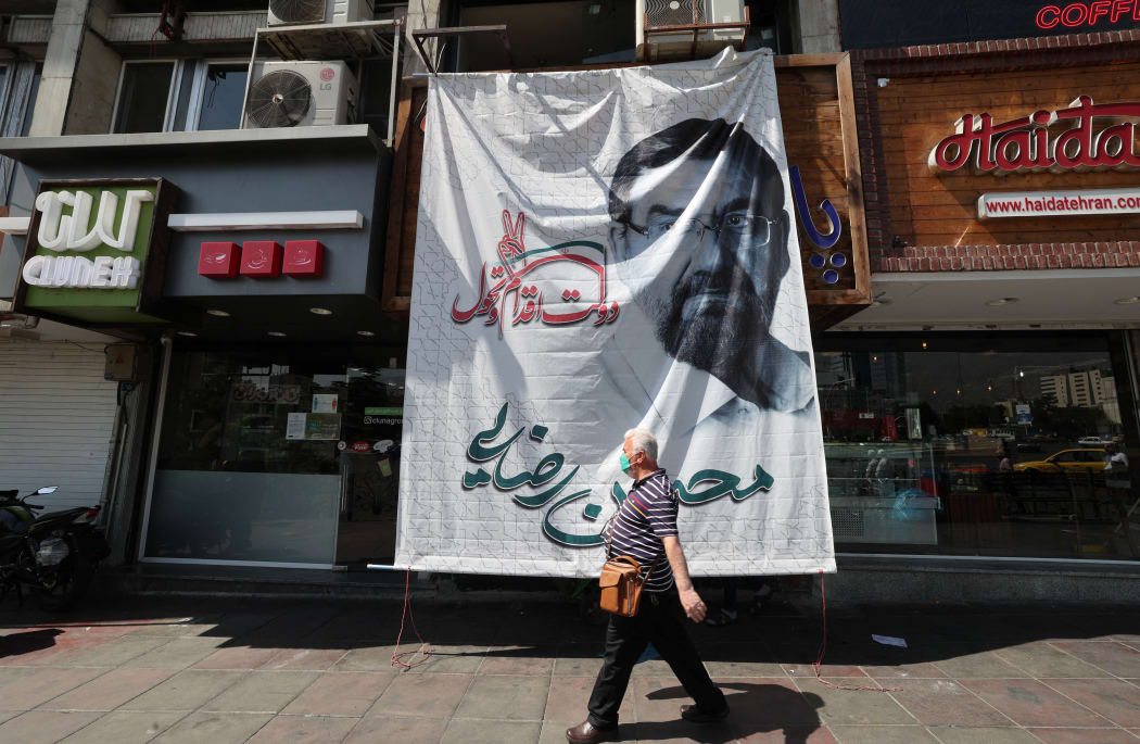 A man walks by an electoral banner showcasing Iran's candidate Mohsen Rezai.