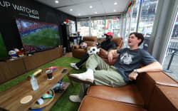 Austin Franklin (right) and Kevin Akoto watch a 2026 World Cup match between Portugal and Uzbekistan from their transparent cube in Times Square in New York, on June 23, 2026. The pair being paid $50,000 by FOX, one of the tournament’s broadcasters, were selected from a field of thousands of eager fans after submitting video applications, to watch every one of the 104 games of the World Cup. (Photo by TIMOTHY A. CLARY / AFP)