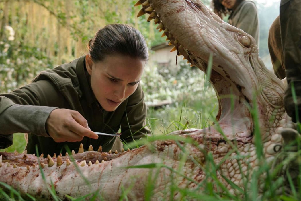 Natalie Portman as Lena inspects an unusual alligator in Annihilation.