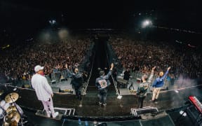 Six60 waving to fans from the stage at Eden Park.