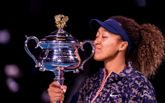 Naomi Osaka of Japan kisses her trophy after winning the Women's Singles Final of the 2021 Australian Open.