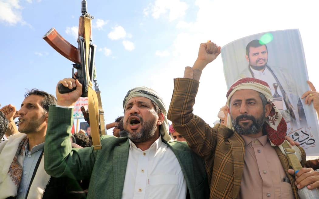 Yemeni men brandish their weapons and hold up portraits of Huthi leader Abdul Malik al-Houthi during a protest in solidarity with the Palestinian people in the Huthi-controlled Yemeni capital Sanaa on January 5, 2024, amid the ongoing battles between Israel and the militant Hamas group in Gaza. Heavy air strikes pounded rebel-held cities in Yemen early on January 12, 2024, the Huthi rebels' official media and AFP correspondents said. The capital Sanaa, Hodeida and Saada were all targeted, the Huthis' official media said, blaming "American aggression with British participation". (Photo by MOHAMMED HUWAIS / AFP)